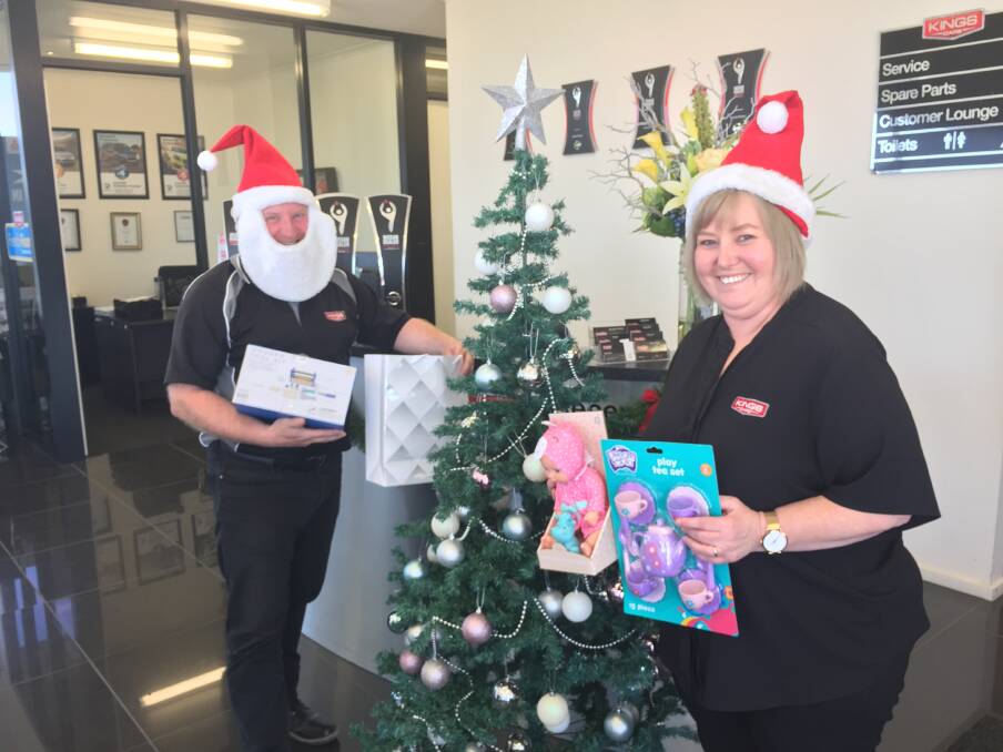 CHRISTMAS SPIRIT: Paul Burn and Natalie Coghlan with some of the donated gifts in the Kings Cars showroom, Ararat. 