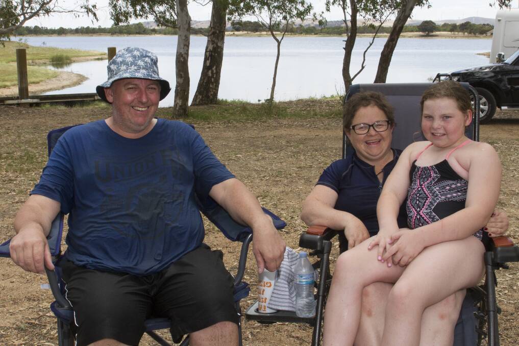 RELAXED: Berwick visitors Andrew and Bobbie Constable with Sophie beating the heat at Green Hill Lake. Picture: PETER PICKERING. 