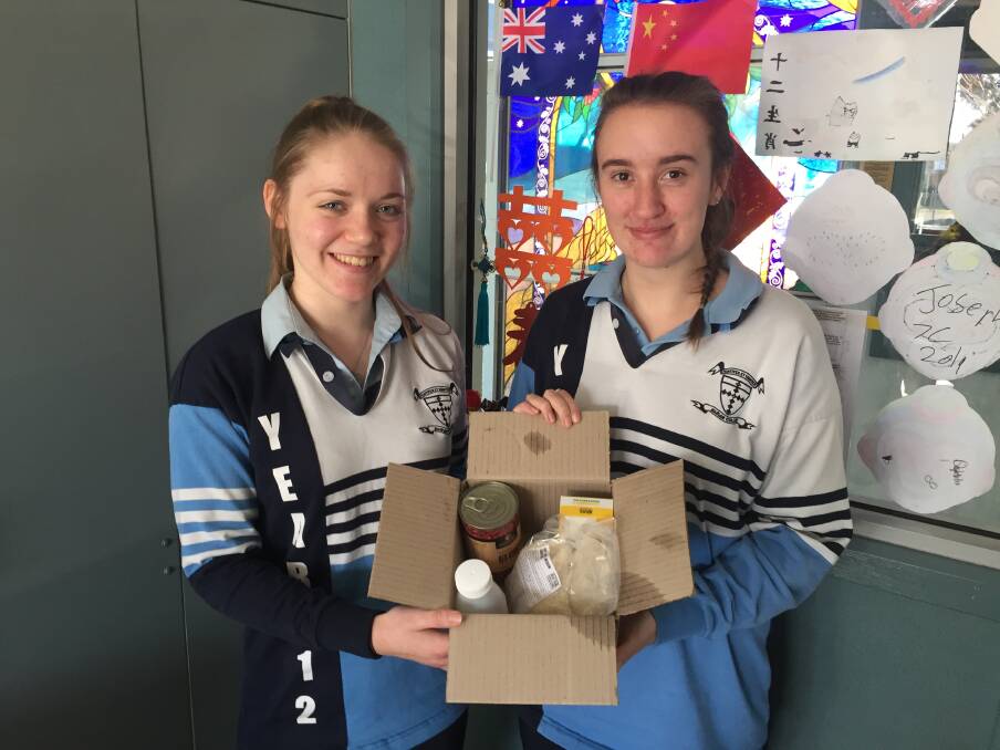 CHALLENGE: Rachel and Emma with a box of their rations for the week.