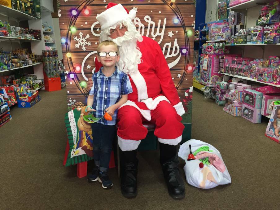 Carl Forshaw as Santa Claus in 2018, with young Henrry at Toyz on Barkly.