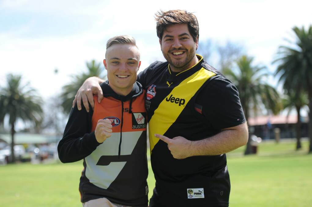 Giants supporter Samuel Leith and Richmond diehard Loucas Vettos look past their differences for a brief moment. Picture: MATT CURRILL