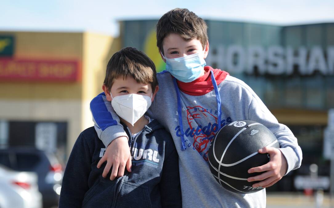 HAPPY TO PLAY THEIR PART: Bailey and Taylor Hartas wearing facemasks last month. Picture: RICHARD CRABTREE