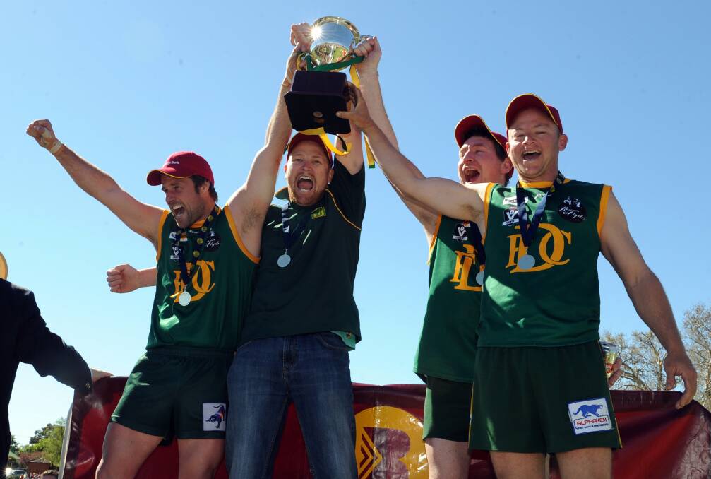 Dean Toet, Josh Cook, Isaac Eldridge and Ash Avery lift the cup after the 2014 reserves grand final. 