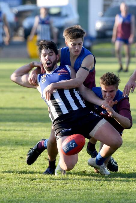 McIntyre is caught in a tackle by Horsham's Matthew Wynne and William Miller. Picture: SAMANTHA CAMARRI