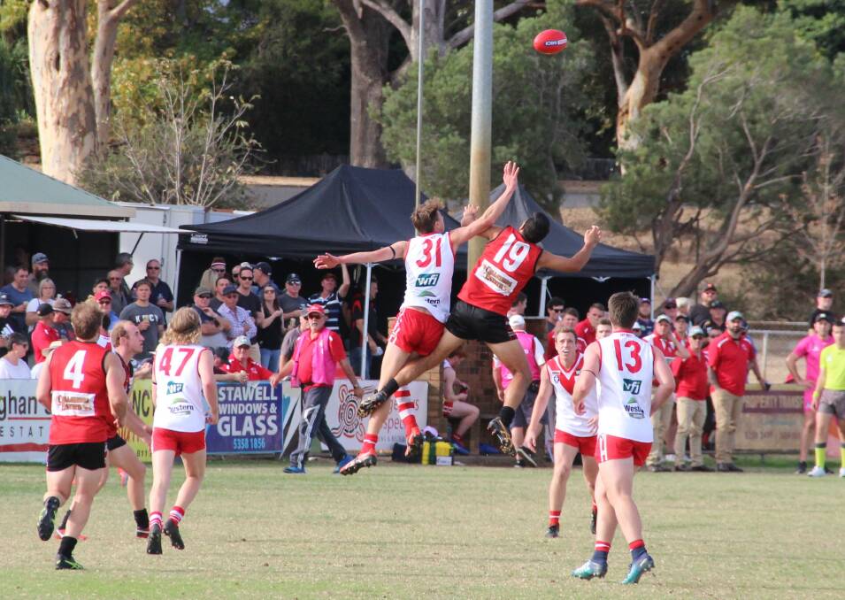 CONTEST: Rats' Cody Lindsay and Stawell Warrior Thomas Taurau fly in front of a bumper crowd in the 2019 Good Friday clash.