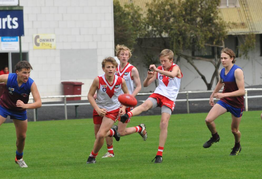 A youngster gets a kick away during the 2019 under-14 grand final. 