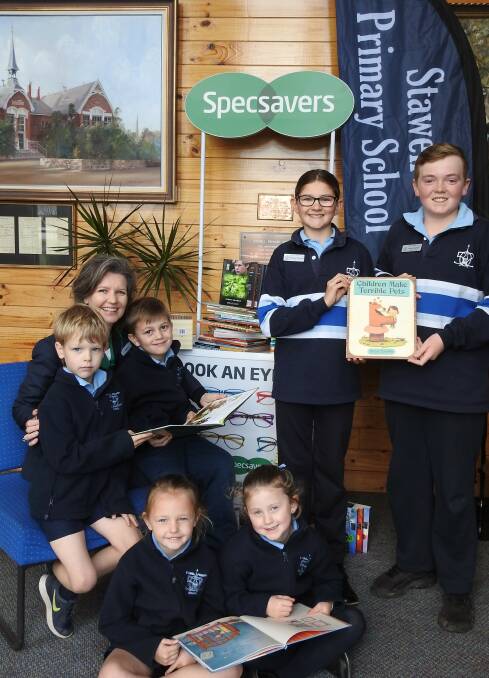 Martie Peters from Specsavers with Harley and Oakley, school captains Georgie and Lewis are standing with Rhani and Makenzie on the floor. Picture: CONTRIBUTED 