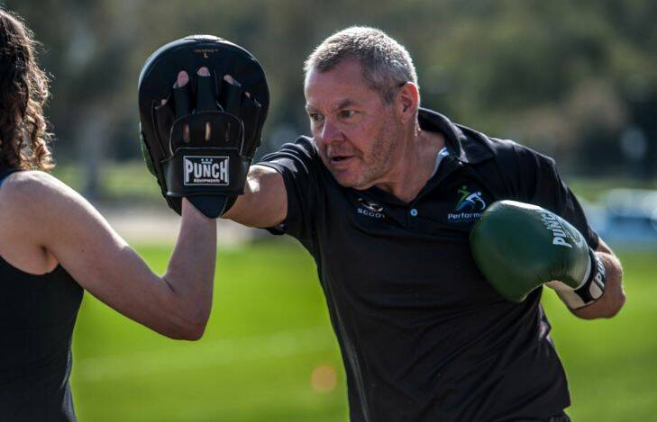 Researchers at the University of Canberra are calling on military veterans and former emergency services personnel to pull on the gloves and step into the ring to help investigate how high-intensity exercise can combat post-traumatic stress disorder (PTSD). Researcher Katie Speer  holds the gloves for study particpant Martin Bigmore. Photo by Karleen Minney.
