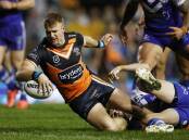 Luke Garner of the Tigers scores a try during his side's NRL win over Canterbury.