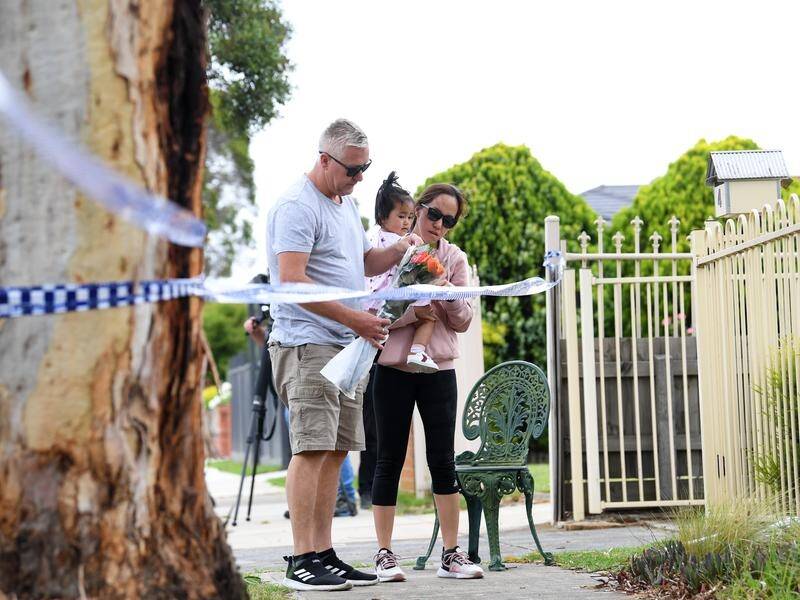 Mourners leave flowers outside the Melbourne home where a woman and three children were found dead.