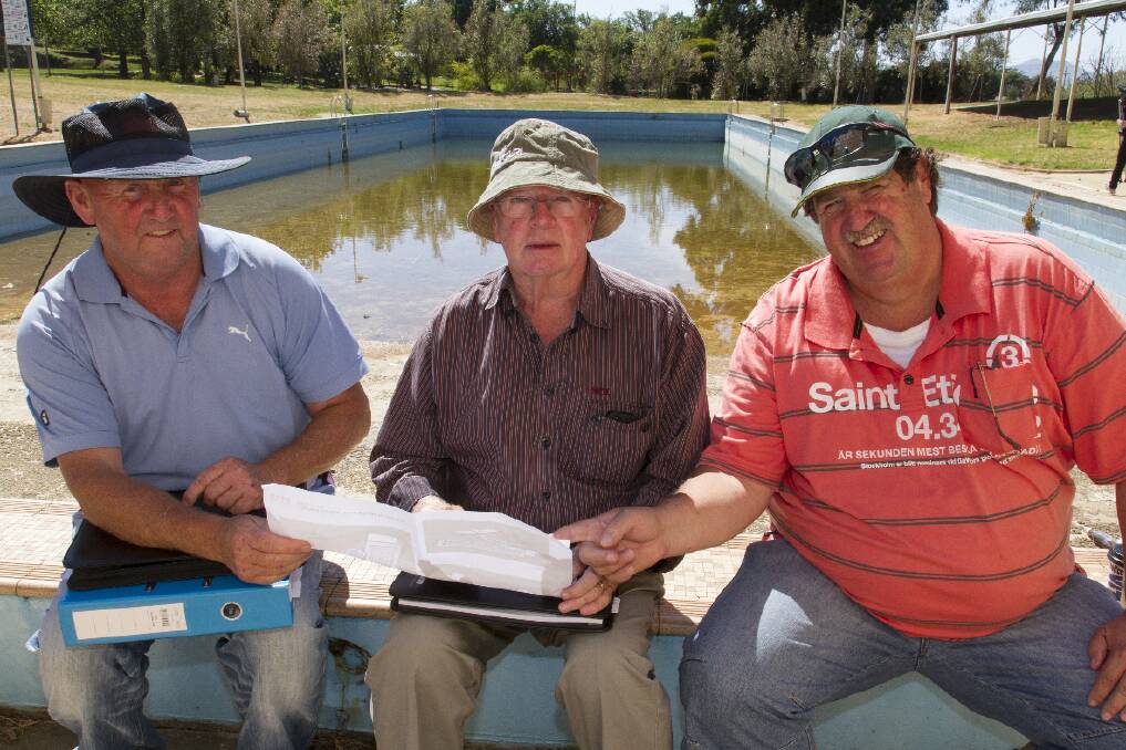 Ararat Olympic Pool Committee member Sandy Laidlaw (right), Peter Farley from Farley Pools and consultant Mike Pettigrew, look over the plans for the redeveloped pool. Picture: PETER PICKERING