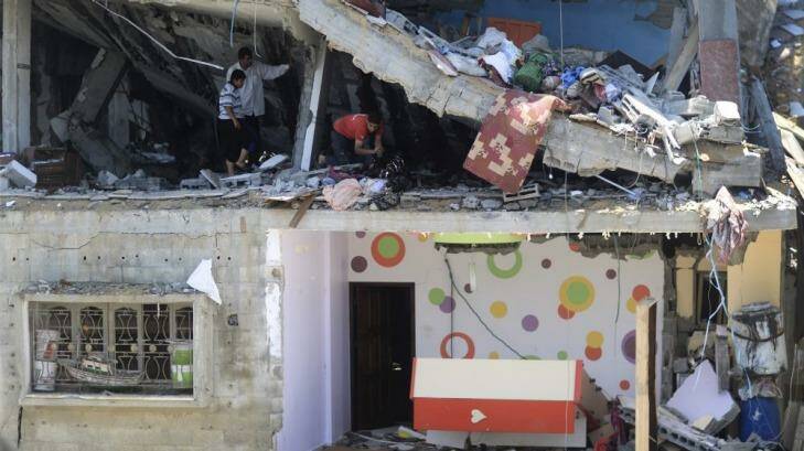 A family inspects the damage to a multi-storey residence hit by an air strike in Gaza City on Thursday. Photo: New York Times