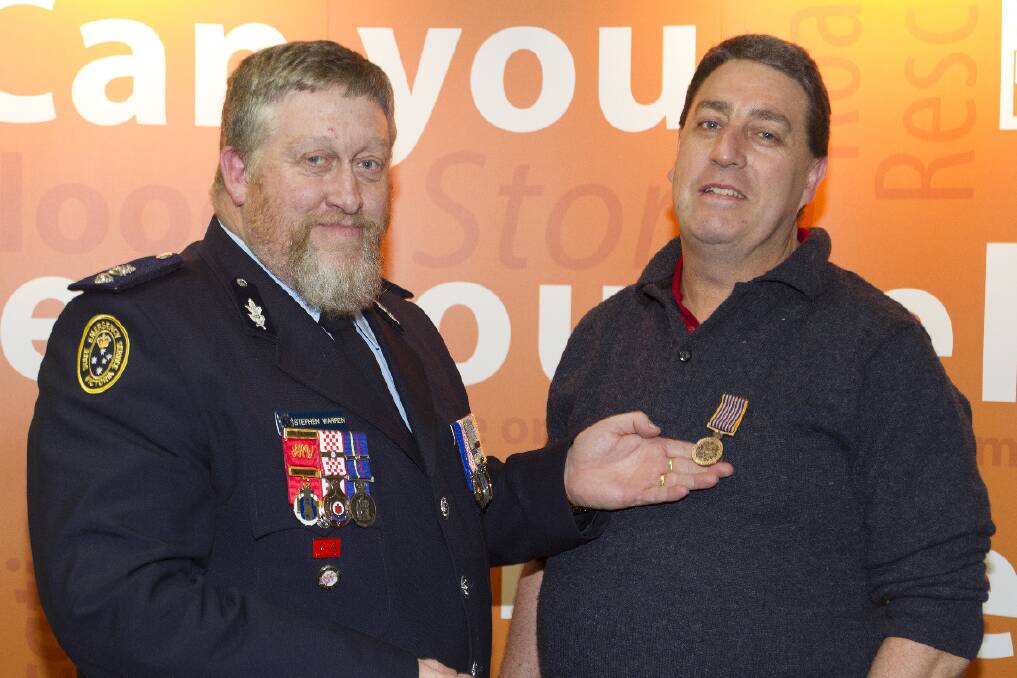 SES regional manager Stephen Warren presents Steven Stacpoole with his 15 year National Medal.