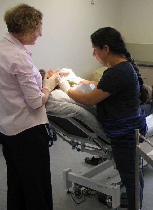 Nurse Joanne Young assisting Dr Novreen Rasool with a procedure.