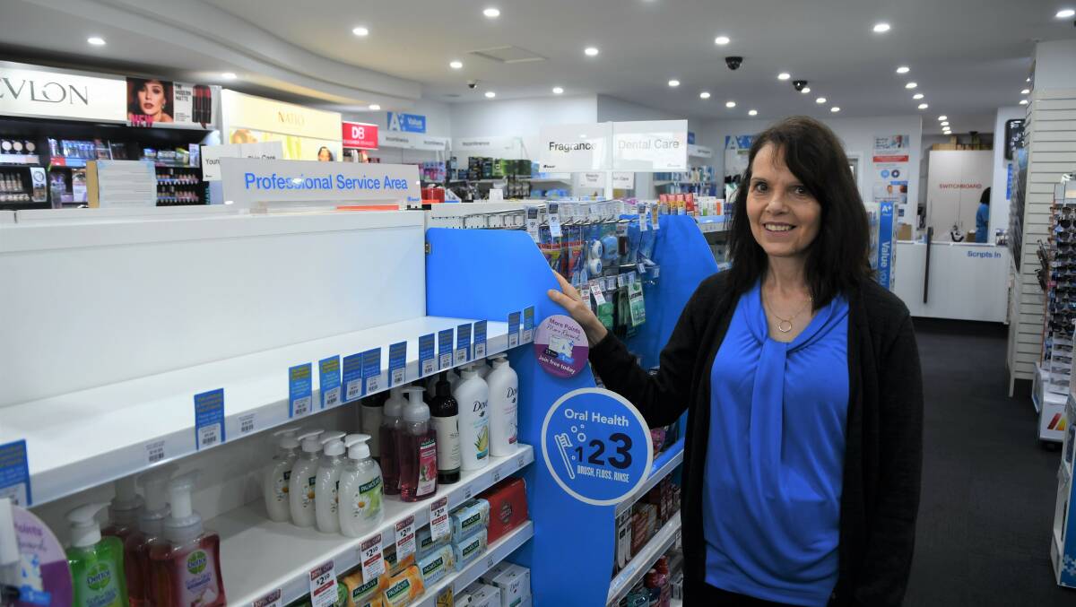 SOLD OUT: Debbie Peachie, Amcal pharmacy assistant, stands next to an empty hand sanitiser shelf. Picture: TAYLOR PADFIELD