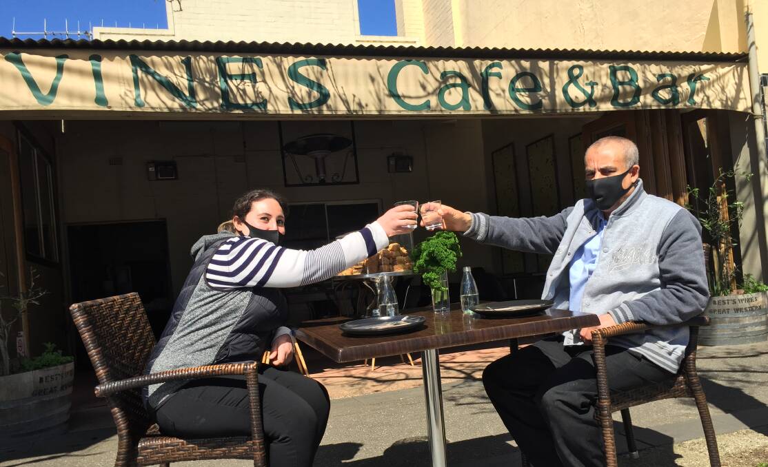 AL FRESCO: Vines Cafe and Bar owners Amal habashy and Esa Besheia celebrating the easing of restrictions. Picture: NICHOLAS SMITH