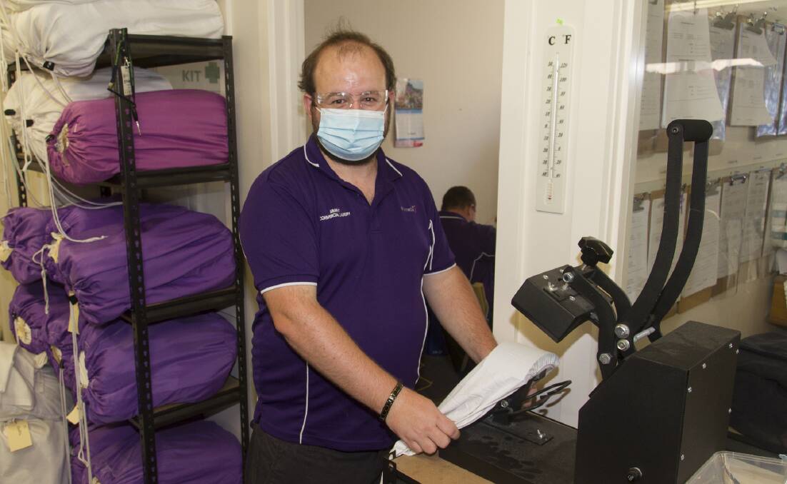 WORKING HARD: Aaron Taylor pressing clothes for Pinnacle's Commercial Laundry service in Ararat. Picture: PETER PICKERING