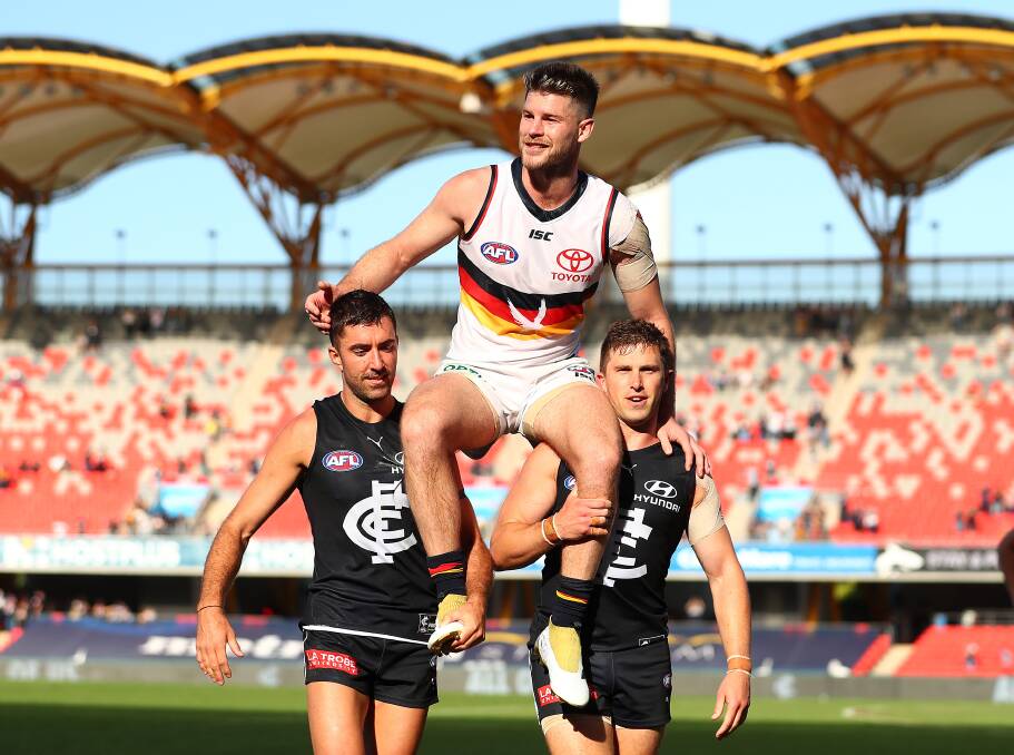 The Crows' Bryce Gibbs is chaired off by best mates Kade Simpson and Marc Murphy, of the Blues, after playing his final AFL match. Photo: Chris Hyde/Getty Images