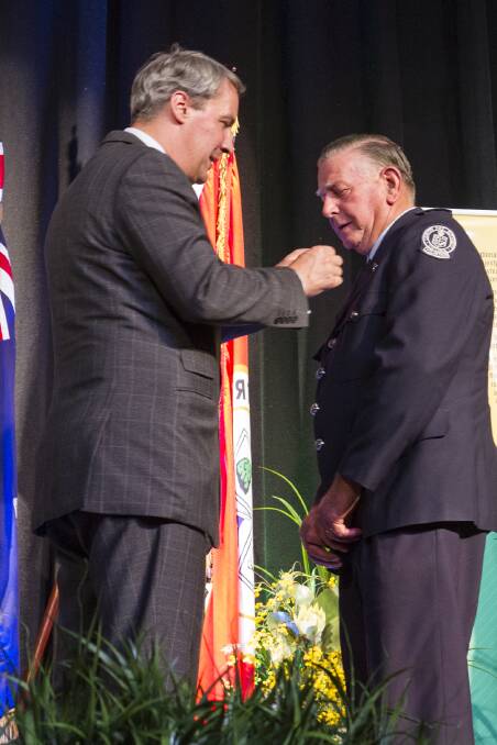 Rob Keith has his National Emergency medal presented by Commissioner Michael Hallowes.