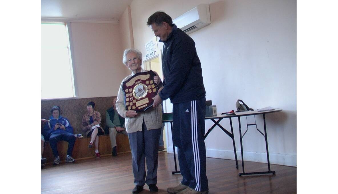 Ivan Howes Memorial winner Bruce Hamilton receives the perpetual shield from Beryl Howes at the Concongella Hall.